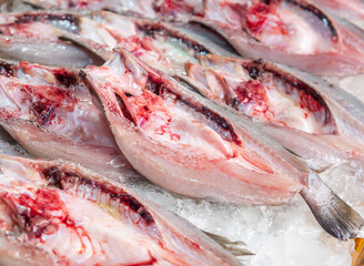 Fresh white snapper cut in half on display for sale in the seafood market. - 505323439