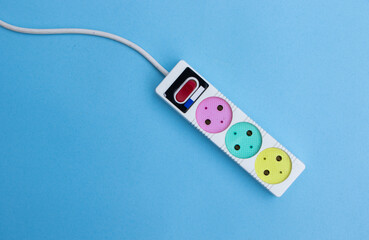 Top view of triple socket European power adapter with different wires at home, blue background.