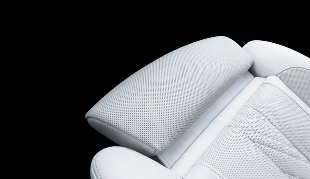 Luxury white leather interior. Part of white leather car seat details with stitching. Interior of prestige car. Comfortable perforated leather seats. Perforated leather.