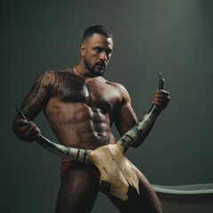 Sexy man with erotic masculine, body six pack hold bull horns. Sexy male torso, seductive stranger with muscular body. Guy hunk, brutal sex symbol. © Volodymyr