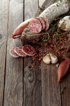 Dry-cured sausage on a old wooden table.