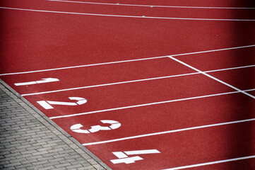 Am Start: Rote Laufbahn mit Statnummern, der Sportplatz, roter Schotter Belag, Sportanlage für den Außenbereich