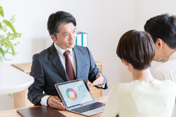 夫婦に営業するビジネスマン