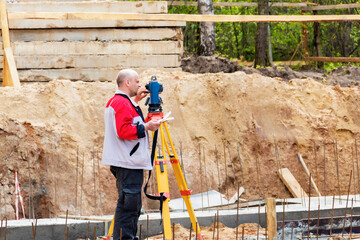Construction of a residential area. Geodetic stakeout. Surveyor at a large construction site. A man...