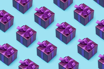 Pattern, happy holidays. Gift boxes in fancy purple paper, copied, cloned on a blue background.