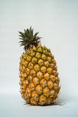 Close-up and detail view of ripe and ready-to-eat yellow pineapple, large and fresh on a white background
