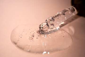 A drop of serum with bubbles on a beige background.