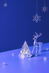  Winter scene with Christmas decorations made of crystal glass. Xmas tree, deer and snowflakes on...