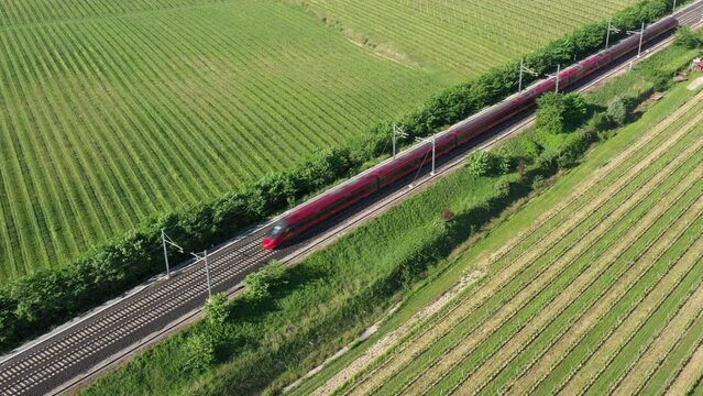 Red train fast moving diagonal top view. High speed train red color faster movement air view.