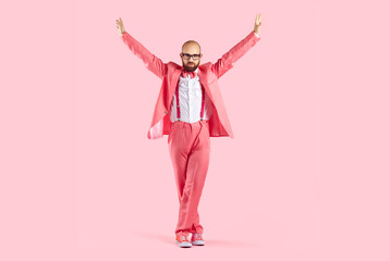 Happy disco man in pink costume isolated on studio background dancing relaxing. Funny male...
