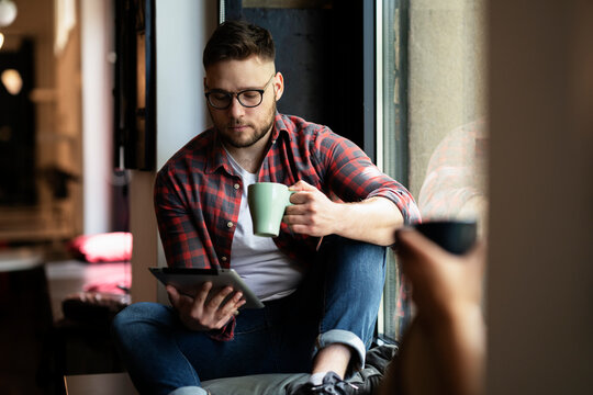 Young businessman drinking coffee in his office