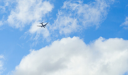 The passenger airplane is flying far away. - obrazy, fototapety, plakaty