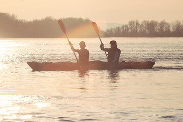 Two active women, best friends kayaking in tandem kayak at Danube river. Kayaking, travel, leisure concept