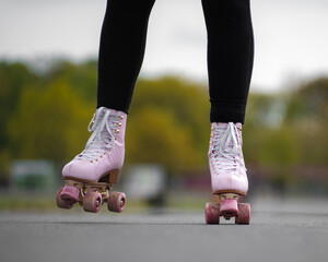 Horizontal picture of person rollerskating, close up of pink vintage quad roller skates. Concept: leisure activities. movement, summer, sports, vacations, free time, outdoor activities. 