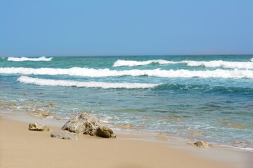 Beautiful view of sandy beach with rocks and sea. Summer vacation