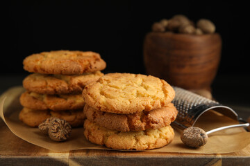 Tasty cookies, nutmeg seeds and grater on wooden board