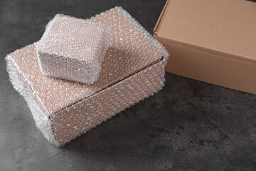 Cardboard boxes with bubble wrap on dark grey table