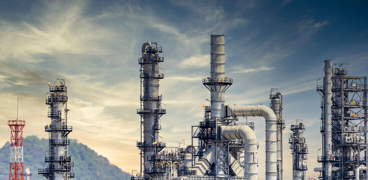 Oil Refinery Plant From Industry Zone, Oil And Gas Petrochemical Industrial With Tree And Blue Sky Background, Refinery Factory Oil Storage Tank And Pipeline Steel, Ecosystem And Healthy Environment.