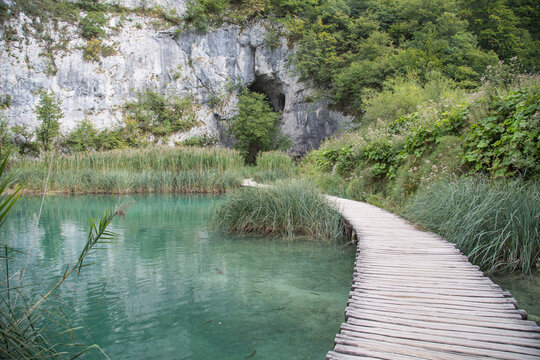 Plitvice Lakes National Park, Croatia, Europe: View to the amazing turquoise water and the tufa slope with its caves while hiking along the boardwalk.