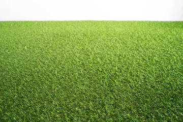 Soft focus and blurred of field turf or artificial grass soccer field, green lawn with white wall background.