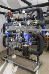 Industrial basement with heating pipes, pressure gauges, valves and heat exchangers