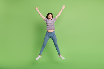 Fototapeta na wymiar Full length body size view of attractive cheerful thin lucky girl jumping having fun free isolated on bright green color background