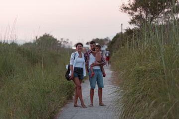 The family walks an idyllic path surrounded by tall grass. Selective focus 