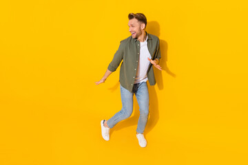 Fototapeta na wymiar Full length body size view of attractive cheerful carefree guy dancing moving having fun isolated over bright yellow color background