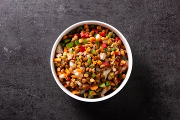 Foto auf Acrylglas Lentil salad with peppers,onion and carrot in bowl on black background. Top view © chandlervid85