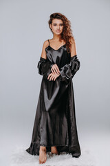 girl in a black robe, pajama on a gray background. home clothes concept. catalog photo