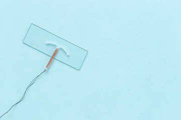 T-shaped copper contraceptive on medical glass. Hormone free contraception concept