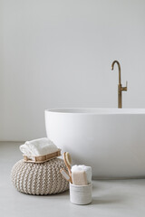 Bathtub with towels and bath accessories in bright room