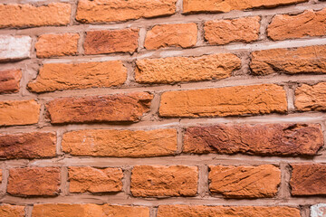 Old red brick fortress wall with gray cement mortar textute. Ancient terracotta brickwork background or pattern