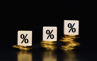 Percent sign on wooden cubes against on gold coin background. Financial.                              