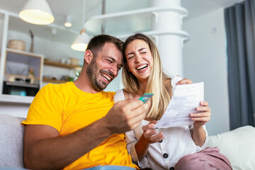 Happy couple managing home finances using digital tablet and credit card for online payment