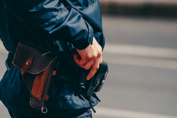 on the side is a man in a police uniform with his hand on a holster in which there is a standard...