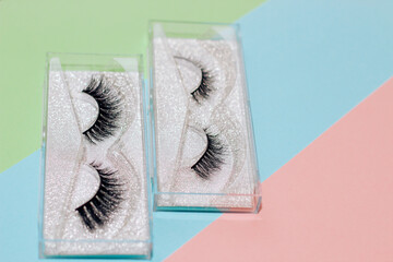 False eyelashes in a box on an abstract paper background