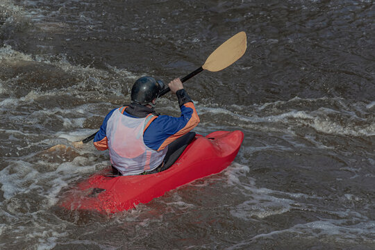 A series of images. Athletes in kayaks and kayaks conquer the stormy waters of the river. Dressed in waterproof clothes and helmets. They hold an oar in their hands. Motion blur
