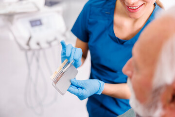 Dentist showing dentail facets color palette to patient