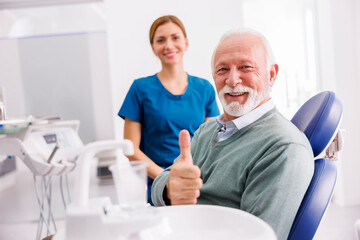 Senior man at dentist office showing thumbs up