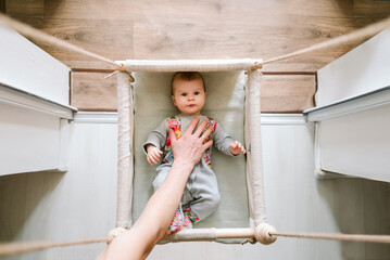 Father take his baby by hand top view.