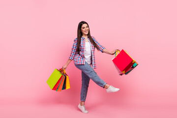 Full size photo of young brunette lady do shopping wear shirt jeans sneakers isolated on pink...