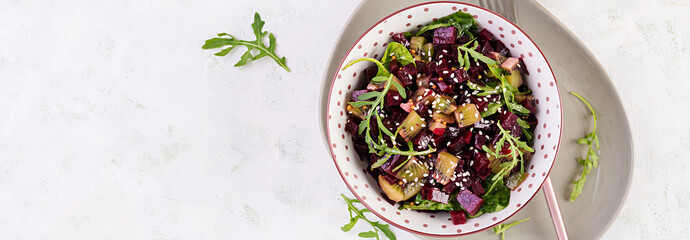 Bowl with salad with baked beetroots, kiwi, spinach, arugula and dressing mustard, oil. Top view, banner