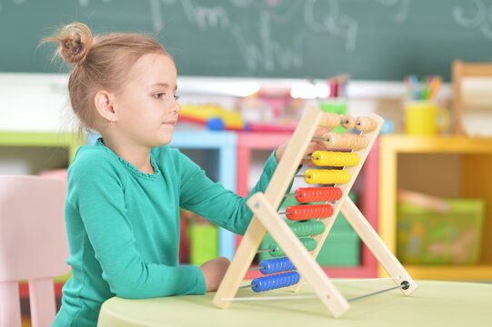 little girl sitting and counting on abacus