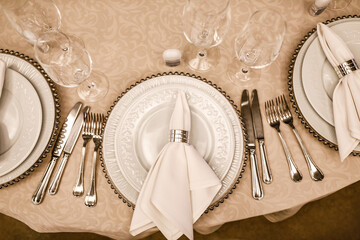 The round table is beautifully set with a view from above. White napkins 