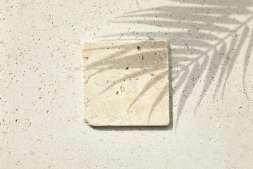 Travertine stone display flat lay podium on travertine stone background and palm shadow. Product...