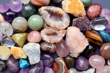 Tumbled and rough gemstones and crystals of various colors. Amethyst, geode amethyst, rose quartz,...