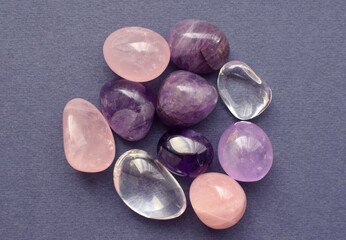 Gems of various colors. Amethyst, rose quartz and rock crystal on gray background