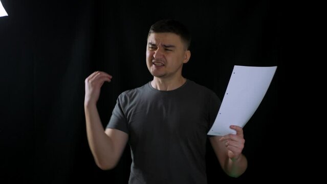 Talented male actor practicing before performance at theater and memorizing lines. Adult artist rehearsing his scenario before tryout for movie role. Preparing to act for jury to earn spot in film
