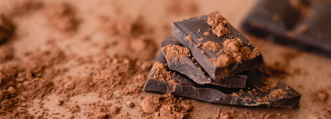 Close up view of natural chocolate and cocoa on brown background, banner.